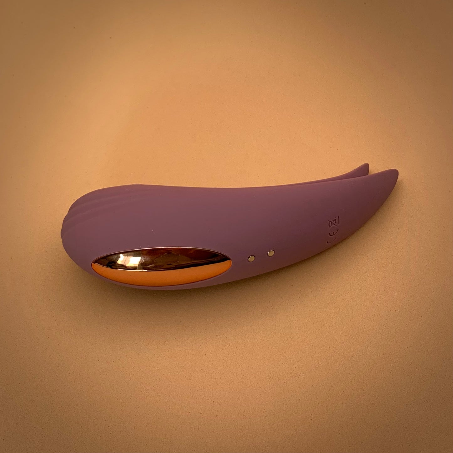 Dual action suction an vibrator toy with curved body and fin-like tail in dusty rose colour