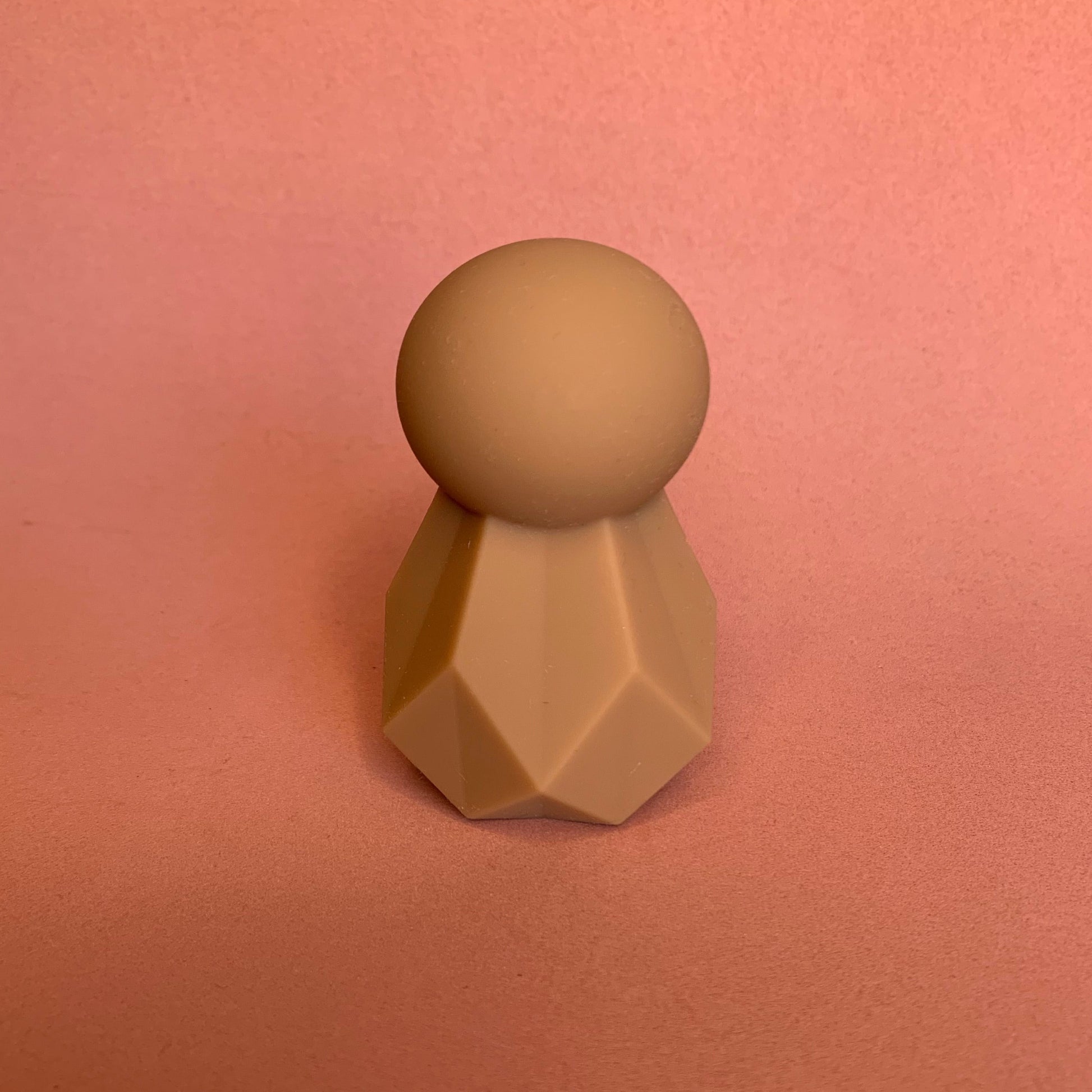 mini clitoral vibrator with round head and geometric shaped body in brown