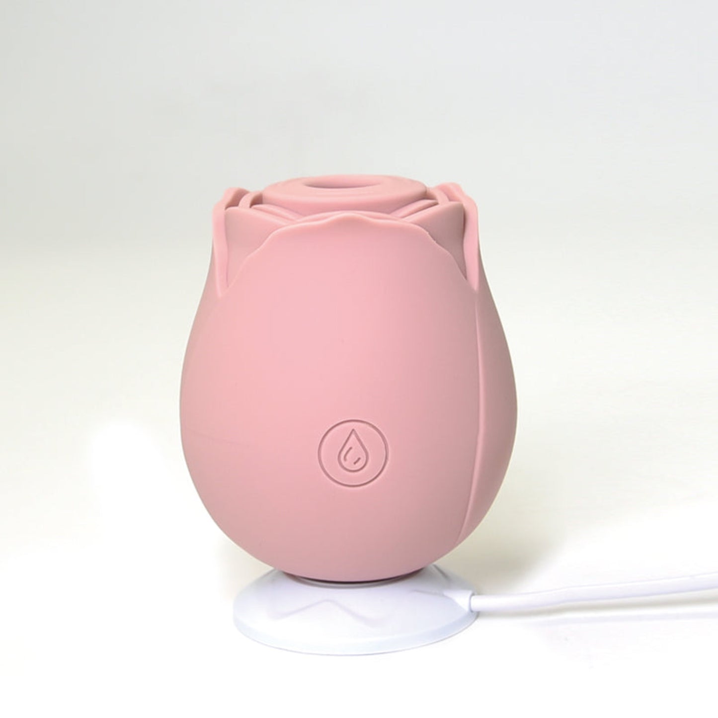 rose shaped clitoral suction toy siting on charger