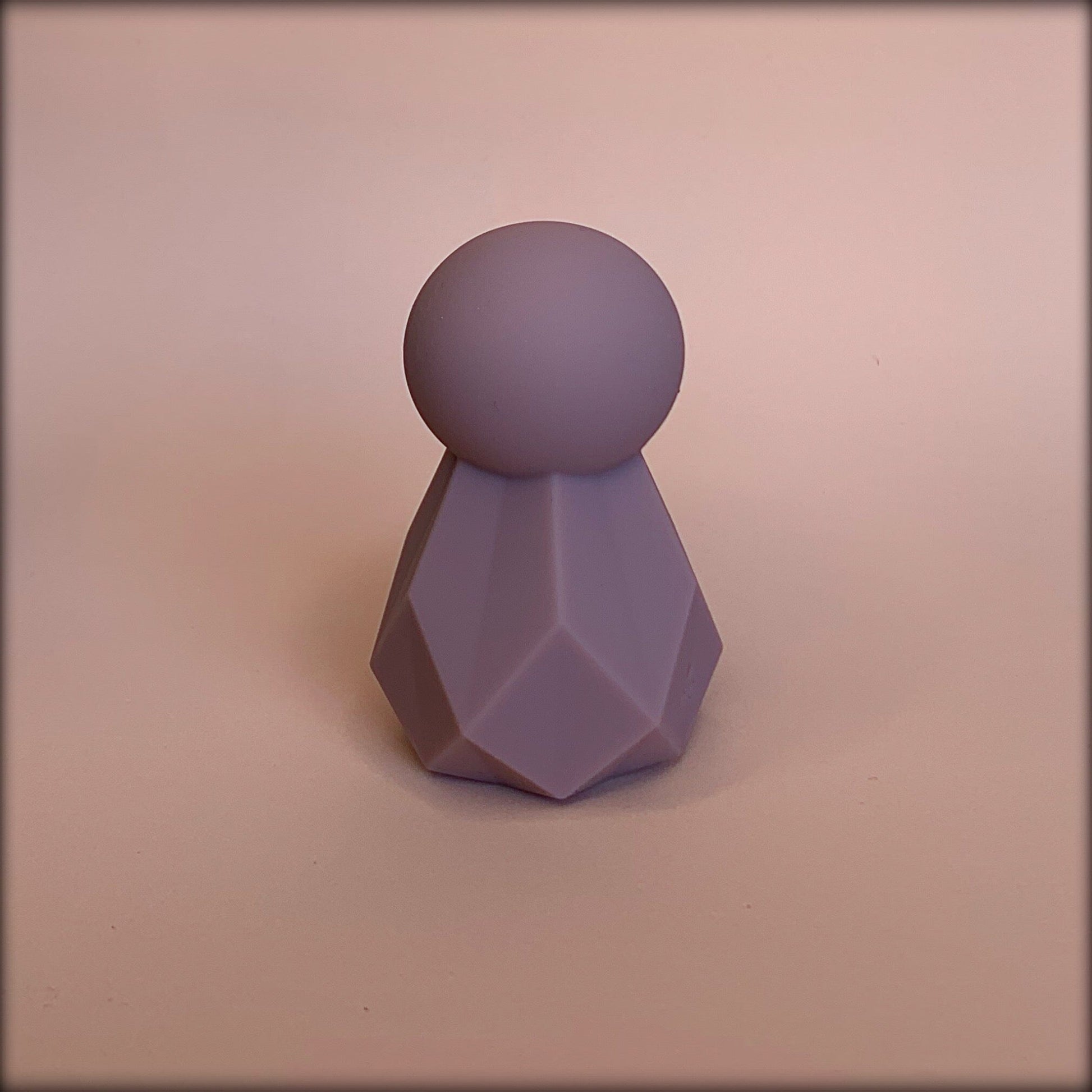 mini clitoral vibrator with round head and geometric shaped body in mauve