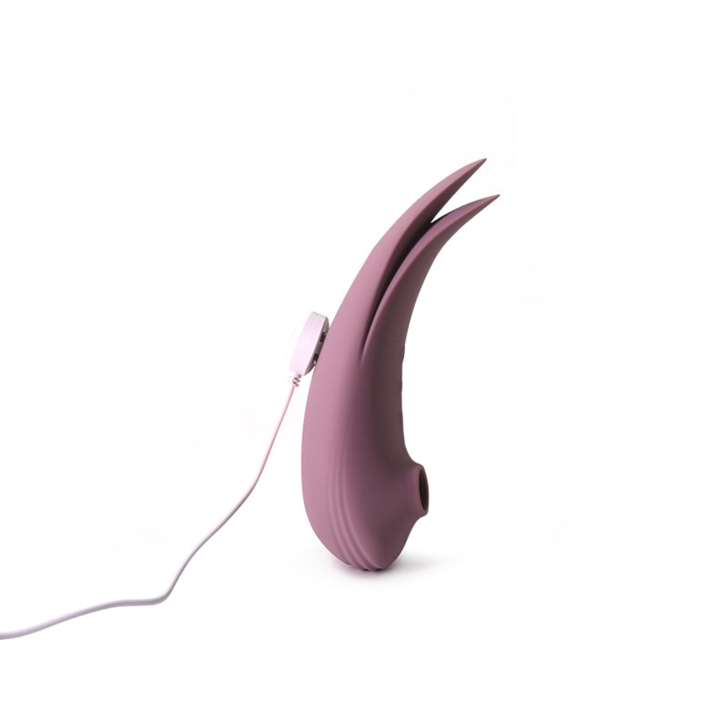 Dual action suction an vibrator toy with curved body and fin-like tail in dusty rose colour, standing upright with charger attached