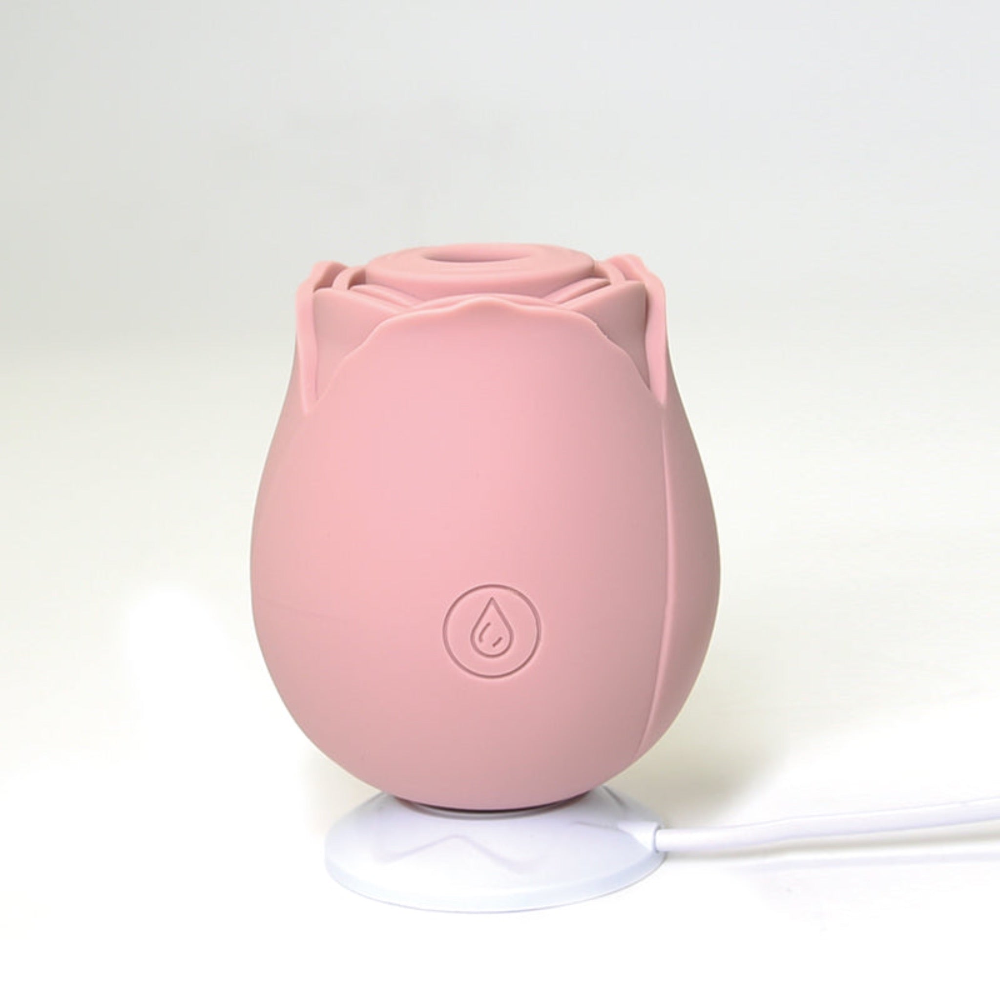 rose shaped clitoral suction toy siting on charger