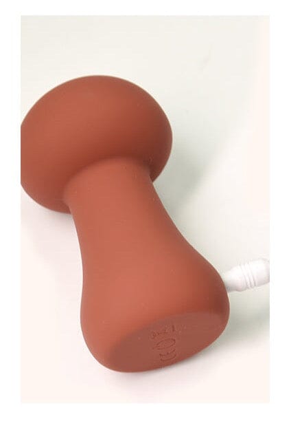 mushroom vibrator lying on its side with charger plugged in